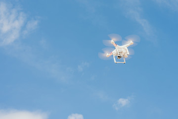 drone against the blue sky. quadcopter shoots the plot from above. Remote quadrocopter flies across the blue sky