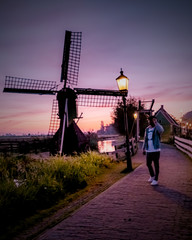 men watching Sunrise at the Zaanse Schans windmill village in the Netherlands, zaanse schans is a small wooden house village in Holland, Dutch windmills