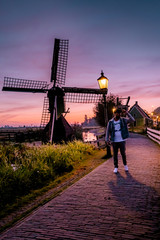 men watching Sunrise at the Zaanse Schans windmill village in the Netherlands, zaanse schans is a small wooden house village in Holland, Dutch windmills