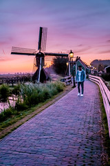 men watching Sunrise at the Zaanse Schans windmill village in the Netherlands, zaanse schans is a small wooden house village in Holland, Dutch windmills
