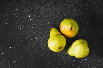 Fototapeta na wymiar Raw pears on the black table