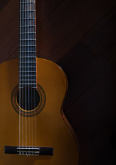 Fototapeta premium Drewniana hiszpańska sześciostrunowa klasyczna gitara akustyczna na tle drewniane tekstury. widok z góry. miejsce na tekst, Zamknij się