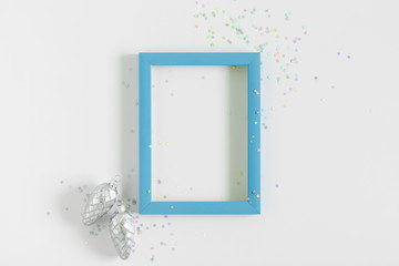 Christmas modern composition. Blue photo frame, Xmas decorations on white background. Christmas, New Year, winter concept. Flat lay, top view, copy space