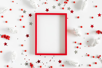 Christmas modern composition. Red photo frame, Xmas decorations on white background. Christmas, New Year, winter concept. Flat lay, top view, copy space