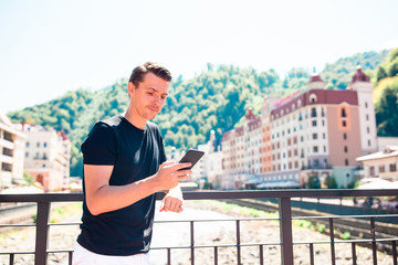 Fototapeta premium Man on the embankment of a mountain river in a European city.