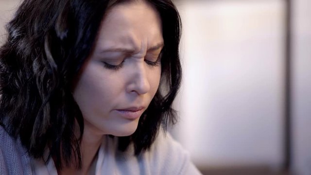 woman crying and wiping tears with paper napkin 