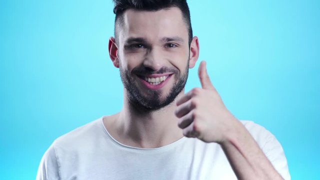 happy man showing thumb up on blue 