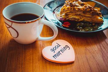 Classic Napoleon cake with coffee cup and the inscription good morning.