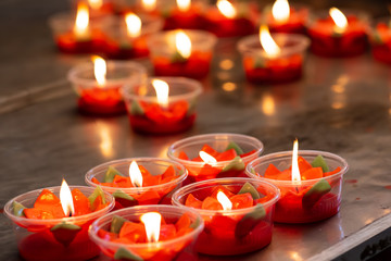 Many burning red flower candles cup at chinese temple