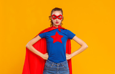 concept. woman in a superhero costume on Colored yellow background