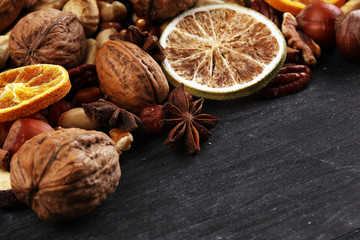 Composition with dried fruits and assorted healthy nuts on rustic background for christmas