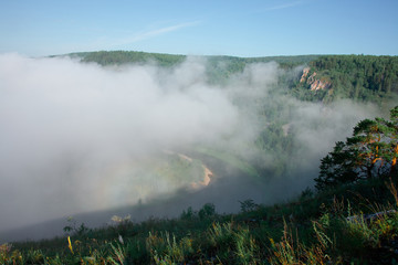 Mountain landscape with rocks and creeping fog. High peaks in the clouds, cold weather. Tourism in the mountains