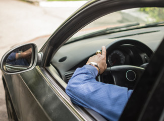 .men's hands on the wheel of a car