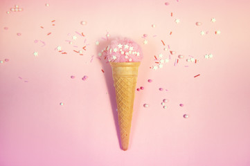 Colorful sprinkles on a pink background, top view with copy space