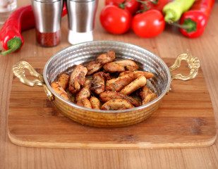 A Different Photo of Fried Chicken Serving in Copper and White Plate from a Close Angle on a Wooden Table