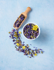 aromatic herbal dry tea lavender and chamomile loose near white cup on blue wood table