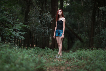 a skinny redhead girl in a brazilian forest