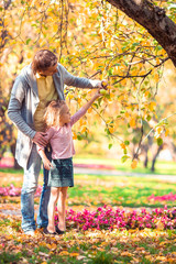 Fototapeta premium Family of dad and kid on beautiful autumn day in the park