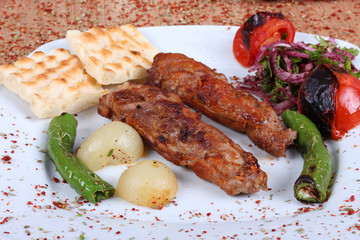 Turkish beef barbecue and fresh vegetables on a wooden table filled with Turkish spices