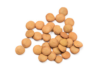 Isolated stack of uncooked lentils on white background from above.