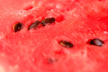 Red pulp and watermelon seeds close-up. Summer berry. Juicy red background.