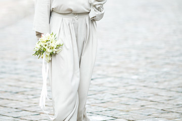 elements of a woman's casual suit with a bouquet of callas