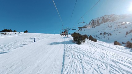Riding ski chair lift on sunny winter day