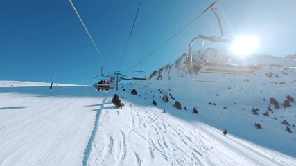 Riding ski chair lift on sunny winter day