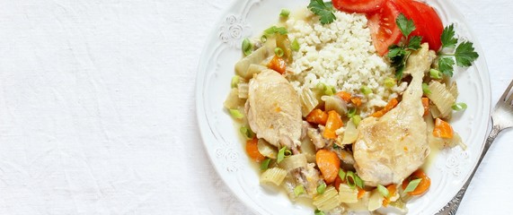 keto dish. Chicken with Cauliflower Rice. low carbohydrates a lot of protein. stewed chicken with celery and carrots. in a white plate on a background of a light tablecloth. top view. copy space.