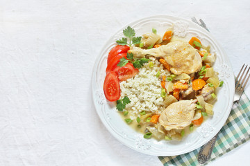 keto dish. Chicken with Cauliflower Rice. low carbohydrates a lot of protein. stewed chicken with celery and carrots. in a white plate on a background of a light tablecloth. top view. copy space.