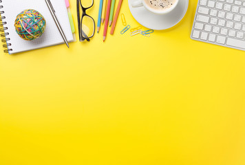 Office yellow backdrop with coffee, supplies and computer