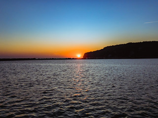 Colorful sunset over the Black Sea coast with ripples on the sea surface on a summer evening with a blue cloudless sky.  Научиться произносить Открыть Google Переводчик	 Оставить отзыв Все результаты 