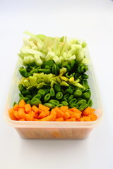 carrot beans peppers celery and onion Vegetable Slices cut as crudite in a plastic container