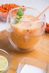 fresh vegetarian fruit smoothie on wooden tray with fresh  bananas, sea buckthorn, lime, melissa and coconut milk . Healthy breakfast. close up
