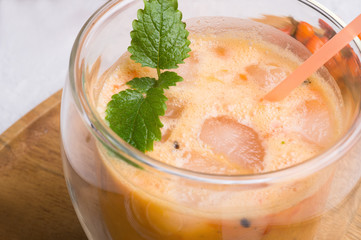 fresh vegetarian fruit smoothie on wooden tray with fresh  bananas, sea buckthorn, lime, melissa and coconut milk . Healthy breakfast. macro shot