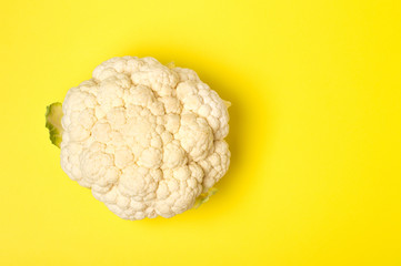 Vegetarian healthy food concept, dieting. Fresh white cleaned cauliflower on yellow background.