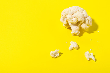 Vegetarian healthy food concept, dieting. Fresh white cleaned cauliflower on yellow background.