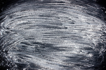 Flour sprinkled on a dark table background. For a plate or menu in the kitchen.