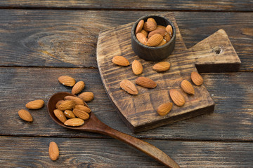 Almonds in a wooden saucer on a wooden table