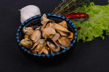 Pickled mussels in the bowl served pepper, garlic and salad