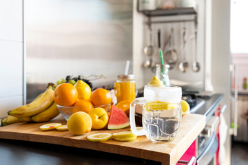 Lemon infusion on kitchen table with various fruit