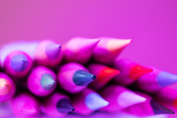 Colored pencils close-up in a trendy neon light. The concept of artistic accessories, creativity. Place for text, minimalism.