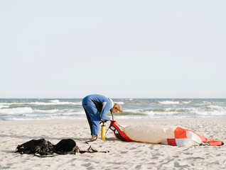 Male surfer preparing a kite on a beach