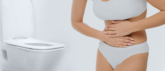 woman suffering bladder ache standing near toilet. Painful urination, or Dysbacteriosis