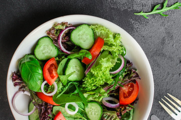 Healthy salad, leaves mix salad (mix micro greens, cucumber, tomato, onion, other ingredients). food background. copy space