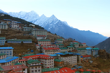 Fototapeta na wymiar Cityscape of Namche Bazaar just before sunrise with Kangtega mountain in the background in Himalayas in Nepal. Outdoors, city view, bed and breakfast, mountains, hiking, travel and tourism concept.