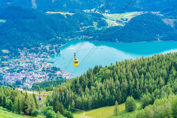 View of St.Gilgen village, Wolfgangsee lake and colorful Seilbahn cable car gondolas from Zwolferhorn mountain in Salzkammergut region, Austria © beataaldridge