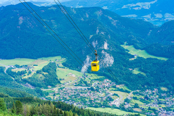 View of yellow Seilbahn cable car gondola against mountains in Salzkammergut region from...