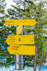 A signpost on Zwolferhorn mountain in St. Gilgen with hiking trail directions. Salzkammergut region in Austria