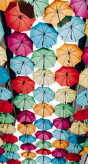 Fototapeta na wymiar Arrangement of colorful umbrellas in rows against the sky